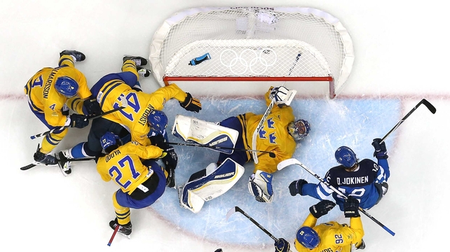 Olli Jokinen of Finland looks on as Henrik Lundqvist of Sweden lies in the crease during the Men's Ice Hockey semi-final