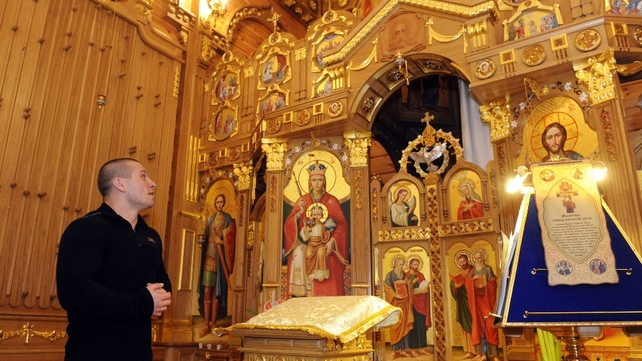 A man looks at icons in a chapel of the main house
