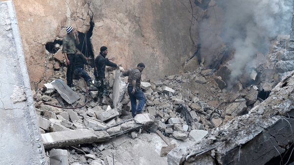 People call for help to extinguish a fire in a building hit by a government air strike in Aleppo (Pic: EPA)