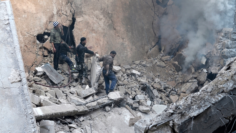 People call for help to extinguish a fire in a building hit by a government air strike in Aleppo (Pic: EPA)