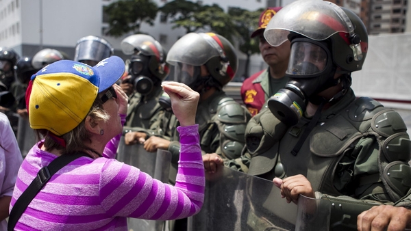 A woman protests in front of members of the Bolivarian National Guard during a demonstration in Caracas (Pic: EPA)