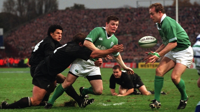 Two men tackle O'Driscoll but, typically, he still gets his pass off against New Zealand in 2001