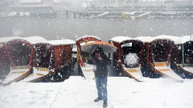 A Kashmiri resident walks during heavy snowfall in Srinagar. Indian-administered Kashmir has remained cut off from the rest of the country for a second day after heavy snow forced the Srinagar-Jammu National Highway to close