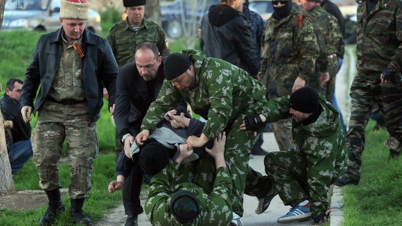 Pro-Russian militiamen beat an unidentified man as Russian soldiers stormed a Ukrainian military air base in the small city of Belbek near the Crimean city of Sevastopol