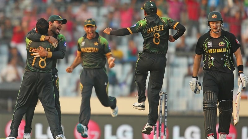 Shane Watson walks (R) as Pakistan players celebrate