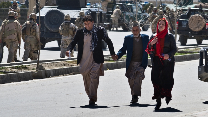 Afghan civilians flee after an Afghan election commission office is attacked by militants
