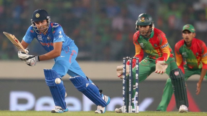 Rohit Sharma bats as Bangladesh wicketkeeper Mushfiqur Rahim looks on