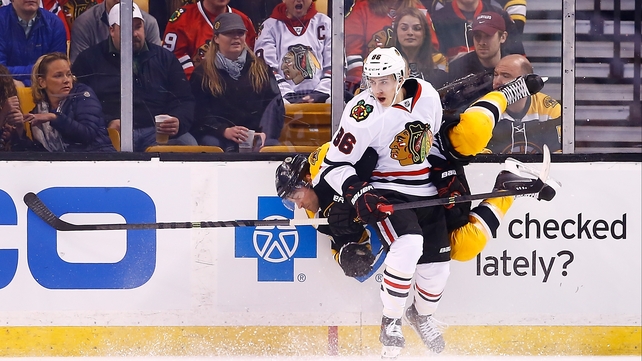 Teuvo Teravainen hits Johnny Boychuk of the Boston Bruins during the game in Boston, Massachusetts