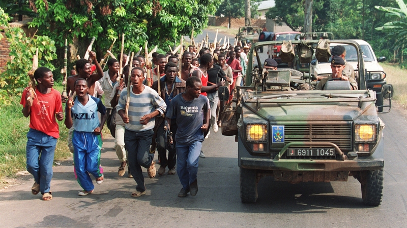 French soldiers on patrol pass ethnic Hutu troops from the Rwandan government forces in June 1994, near the border with Zaire