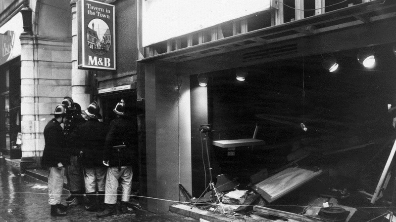 Firemen survey the damage outside the 'Tavern in the Town' pub following a bombing in 1974