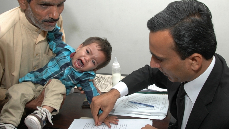 A Pakistani lawyer takes the thumb impression from the nine-month-old baby