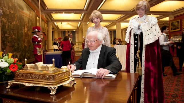 He signs a book at Guildhall in London in the presence of Mayor Woolf