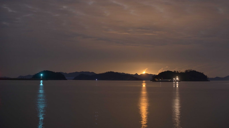 Flares of rescue teams are seen as the search of the capsized ferry continues overnight