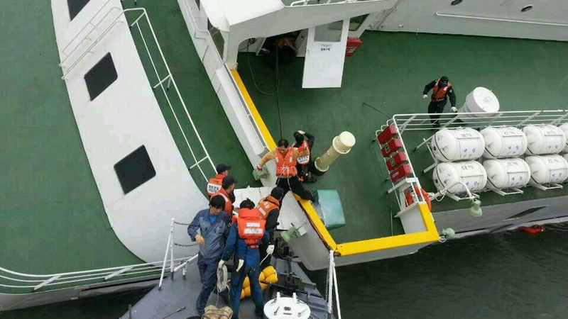 Captain Lee Jun-Seok receives help from maritime policemen to escape after the ferry sank