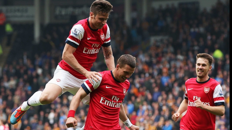 Lukas Podolski (C) of Arsenal celebrates with team mate Olivier Giroud (L) after scoring his side's second goal against Hull