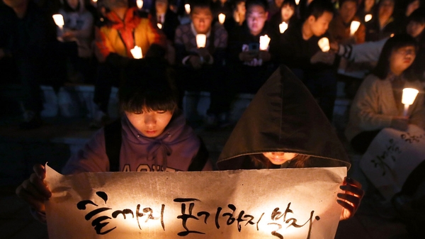 People hold candles as they pray for the safe return of passengers of the sunken ferry in Ansan, South Korea