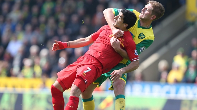 Norwich City's Michael Turner has a tight grip on Liverpool's Luis Suarez during a Premier League clash at Carrow Road
