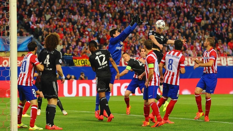 Gary Cahill gets to a cross ahead of Atletico 'keeper Thibaut Courtois