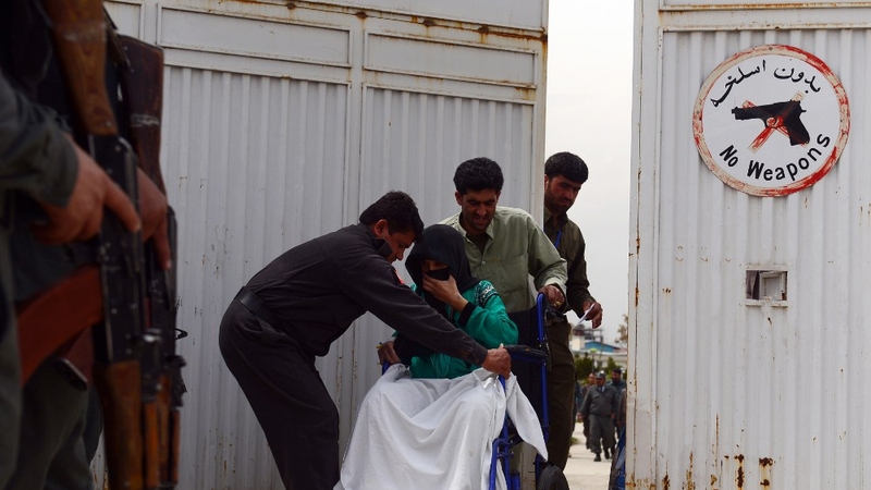 hospital attendants help a patient at the gate of the Cure Hospital