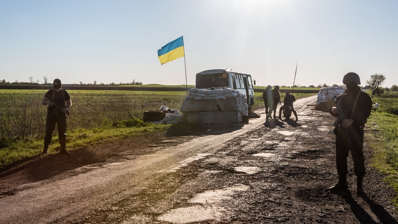 Ukrainian military personnel guard a check point near the town of Barvinkova