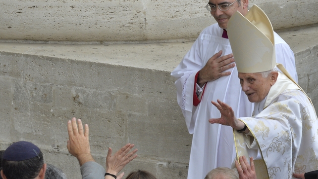 Pope emeritus Benedict XVI waves as he leaves after the canonisation mass