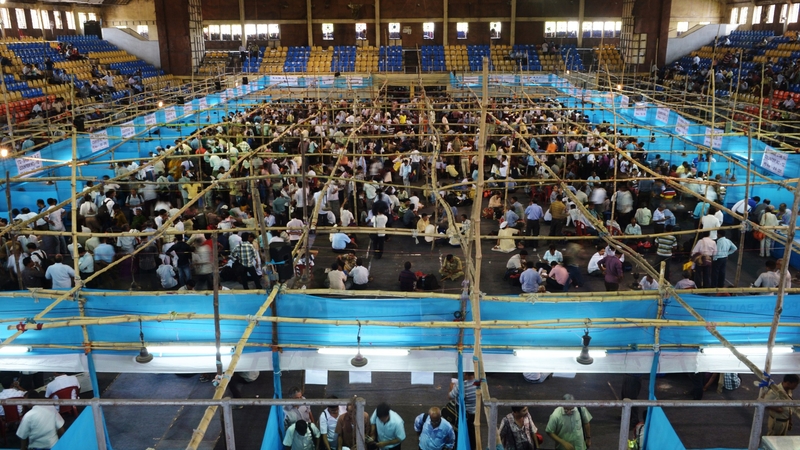 Indian election officials distribute electronic voting machines to polling officials