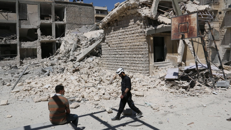 A rusty basketball hoop stands amid destruction in the courtyard 
of the school destroyed by the air strikes