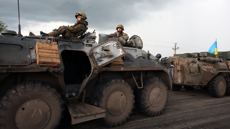 Unmarked soldiers wait on the road as separatists block the Kramatorsk road