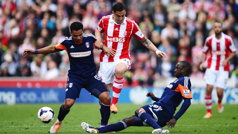 Geoff Cameron of Stoke City rides the challenge of Kieran Richardson (L) and Mahamadou Diarra