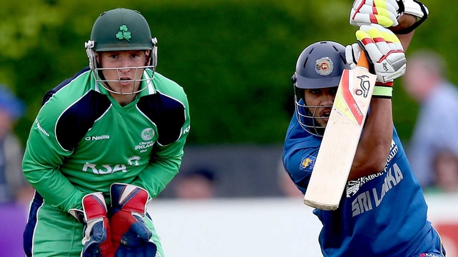 Ireland wicketkeeper Gary Wilson watches as Dinesh Chandimal bats the ball away