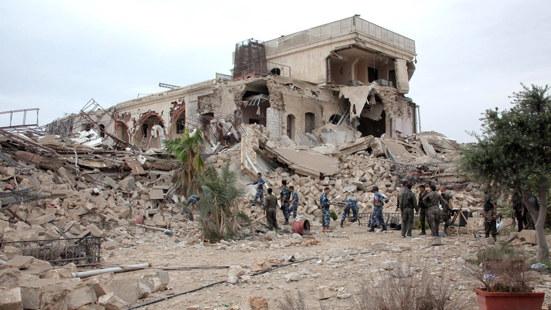 Syrian government forces sift through the rubble following the explosion