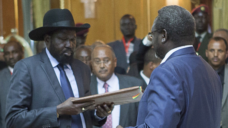 Salva Kiir (L), President of South Sudan, and Riek Machar (R), SPLM Opposition leader, hand over the Cessation of Hostilities treaty