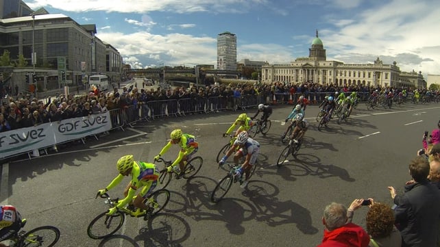 The Peloton travels across Matt Talbot Bridge past the Customs house during stage three of the Giro D'Italia, in Dublin