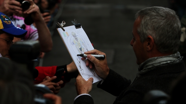 Stephen Roche signs a sketch of his son Nicolas at the finish line in Dublin on Sunday