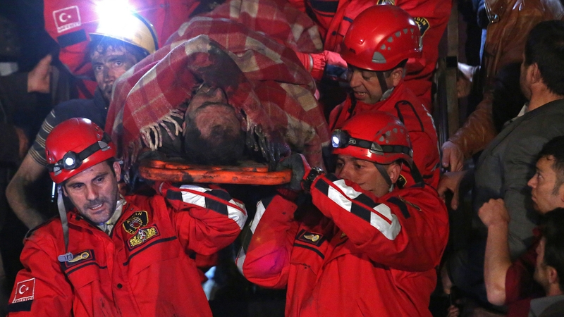 A miner is carried to an ambulance by rescue workers from the coal mine in Soma, Manisa, Turkey