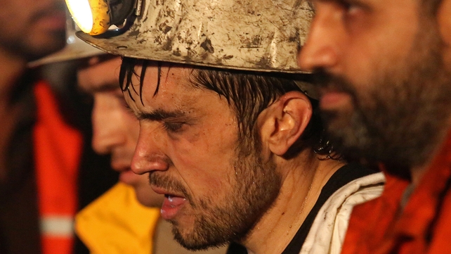 Miners are helped by rescue workers and friends after the blast