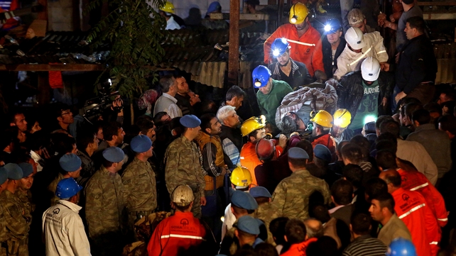 A body is carried from the mine as rescue operations continue