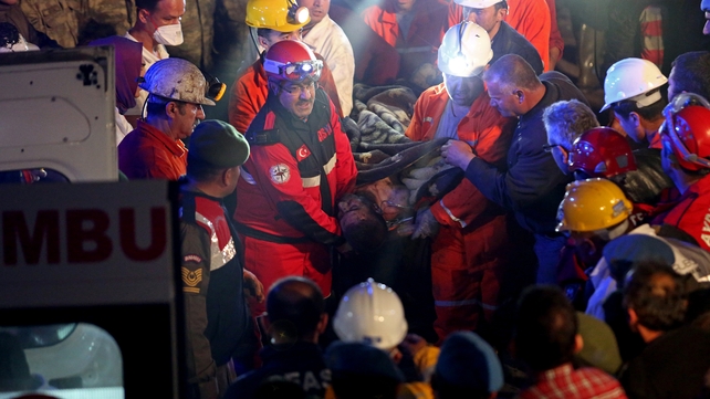 Victims of the mine fire and blast are carried to ambulances to receive medical aid