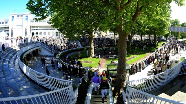 Jockeys make their way to the parade ring at Longchamp