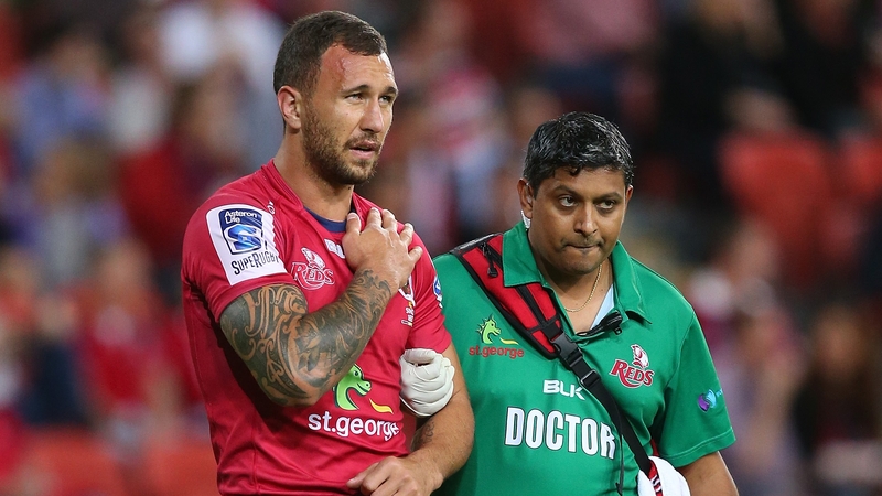 Quade Cooper leaves the field at Suncorp Stadium clutching his injured shoulder