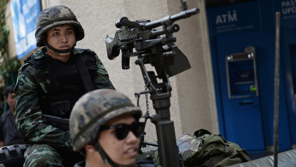 Soldiers in a jeep mounted with a machine gun secure a main intersection in Bangkok
