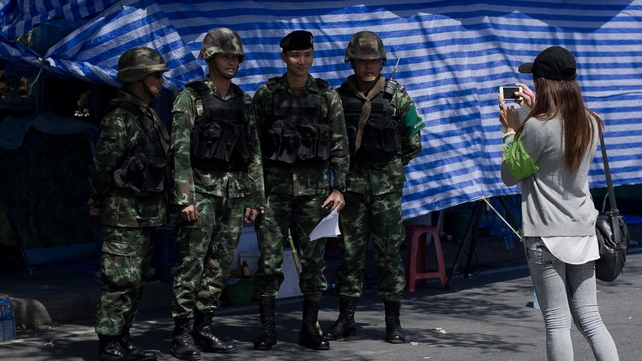 Thai soldiers pose for a photograph as they guard an area near government buildings in Bangkok