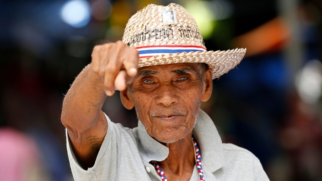 A Thai anti-government protester gestures as he celebrates the army's declaration of martial law