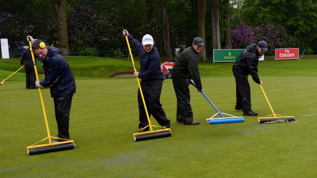 Ground staff work to clear water from the course as the start is delayed due to flooding during day three of the BMW PGA Championships at Wentworth