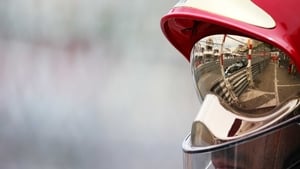 A reflection of Nico Rosberg is seen in the helmet of a course marshall during the Monaco Formula One Grand Prix
