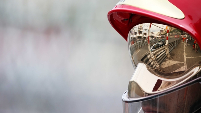 A reflection of Nico Rosberg is seen in the helmet of a course marshall during the Monaco Formula One Grand Prix