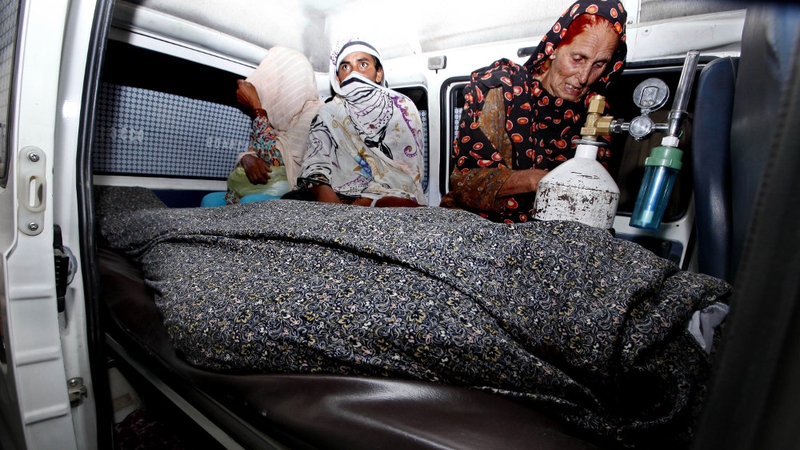Relatives transport the body of Farzana Iqbal who was beaten to death on Tuesday