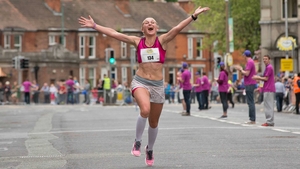 A competitor celebrates crossing the line in the Flora Women's Mini Marathon on Monday