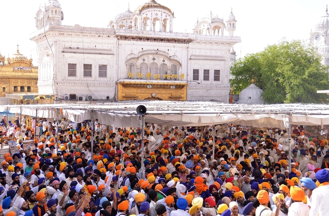 Two groups of Sikhs sporting blue and saffron turbans chased each other with swords