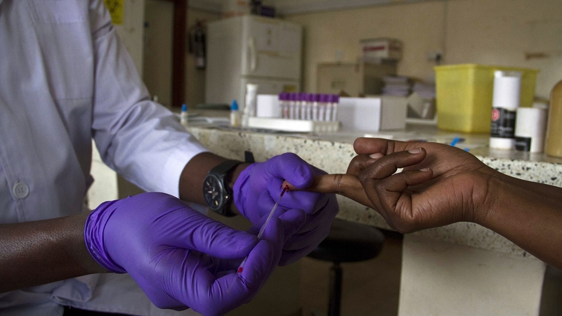 A lab technician draws blood from a patient for HIV testing at the Aids Information Centre in Kampala